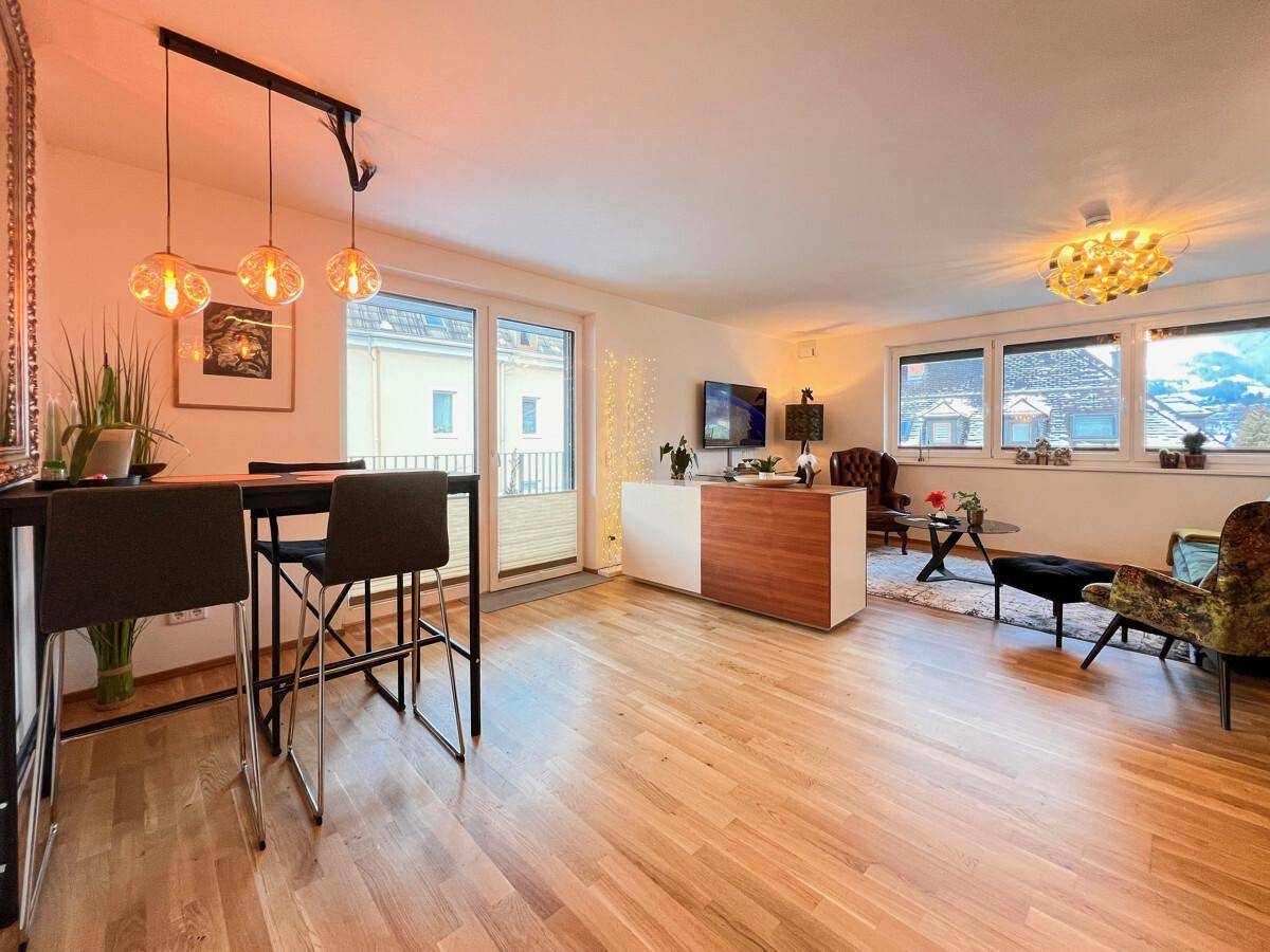 Offener Wohnbereich mit Küche, Essbereich und Zugang zum Balkon, hell und modern.