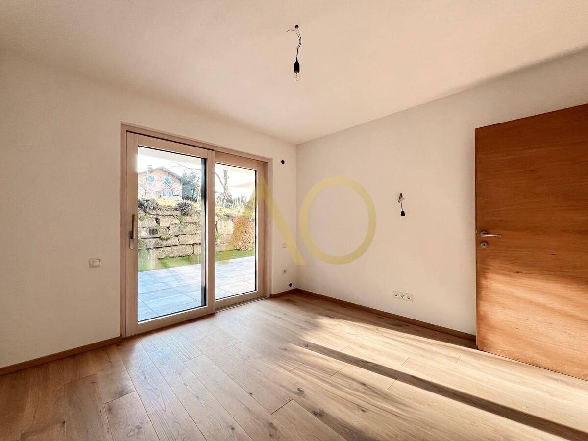 Helles Schlafzimmer mit Holzboden und direktem Zugang zu einer Außenterrasse.