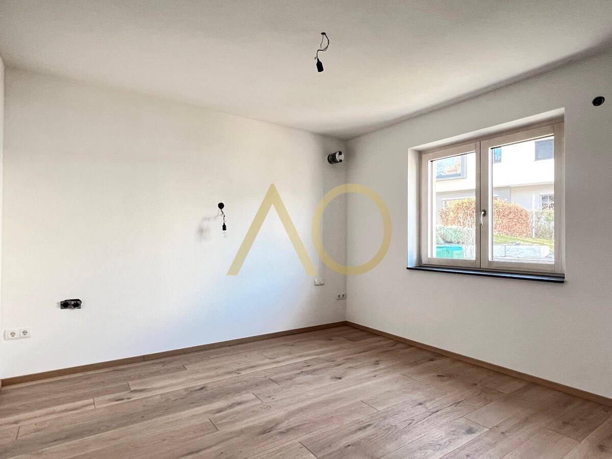 Geräumiges Schlafzimmer mit Holzboden und Fenster mit Blick auf die Umgebung.
