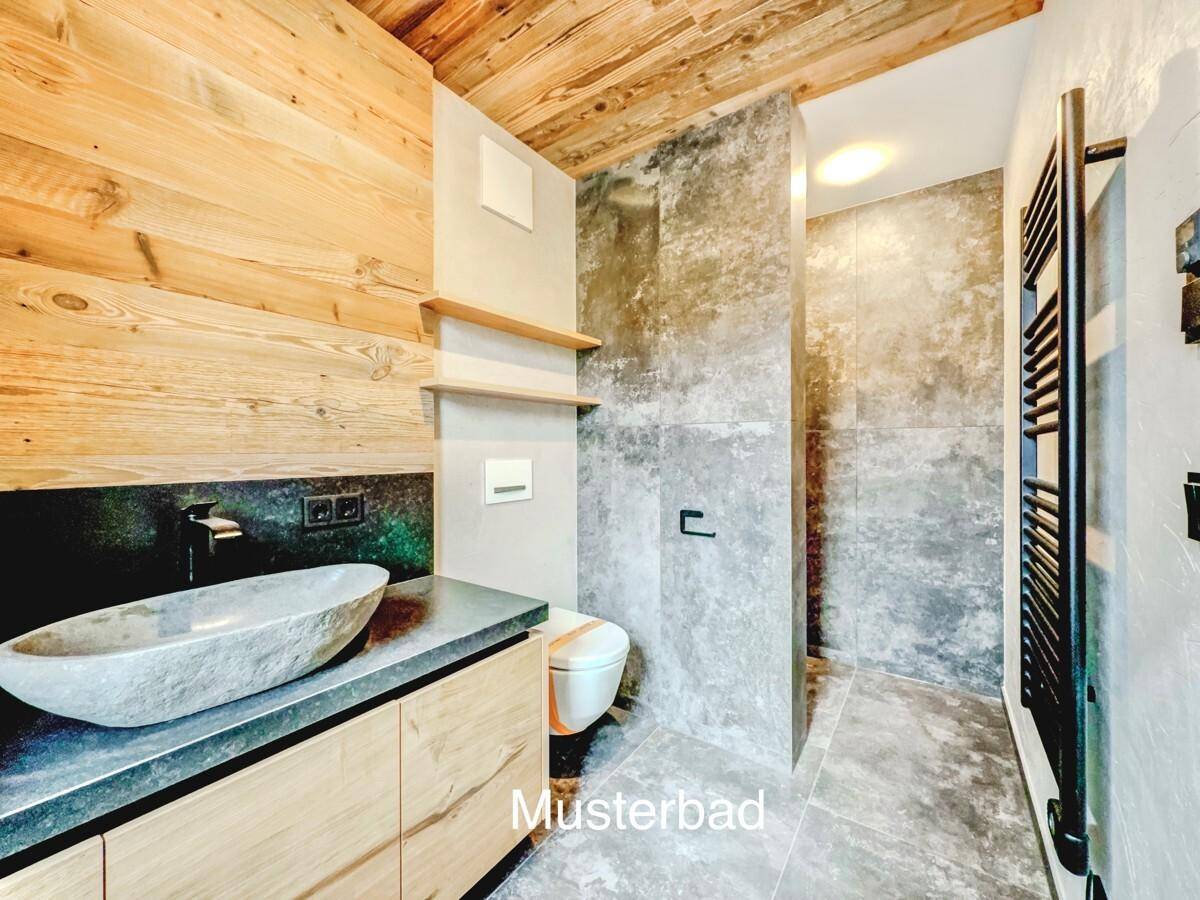 Modernes Badezimmer mit Steinwaschbecken, Holzelementen und grauen Fliesen.