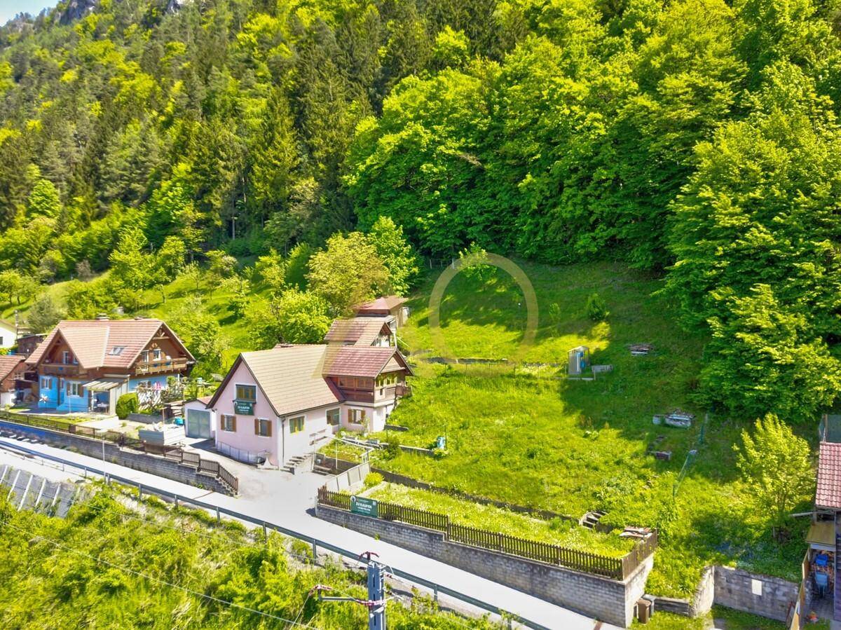Weitläufige Luftaufnahme des Anwesens, eingebettet in eine grüne Hügellandschaft.