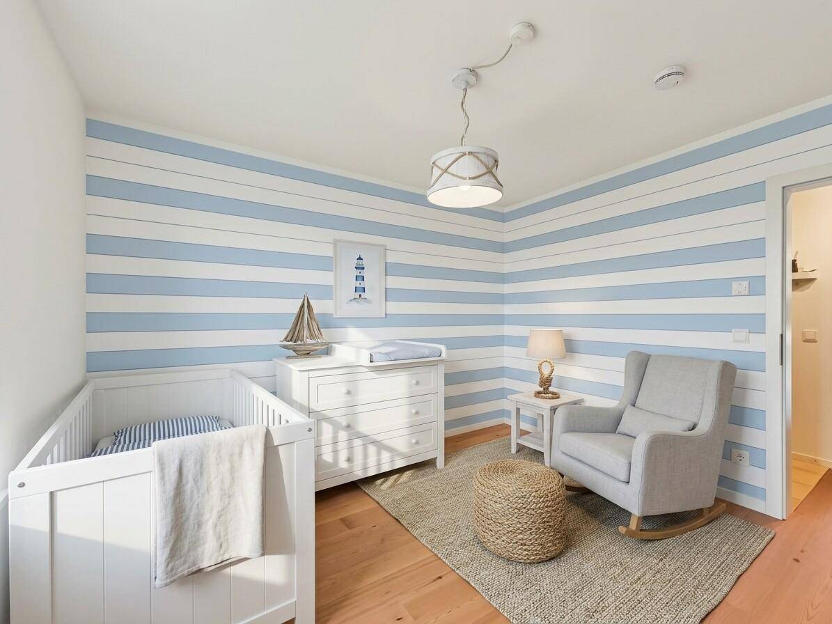 Helles Kinderzimmer mit blau-weiß gestreiften Wänden, Babybett und Schaukelstuhl.