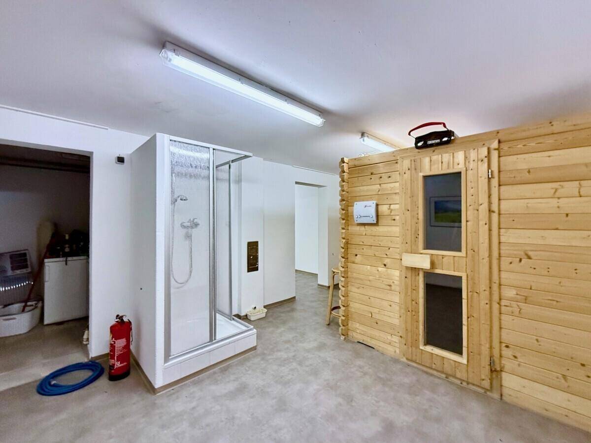 Wellnessbereich im Untergeschoss mit einer Holzsauna und einer separaten Duschkabine.