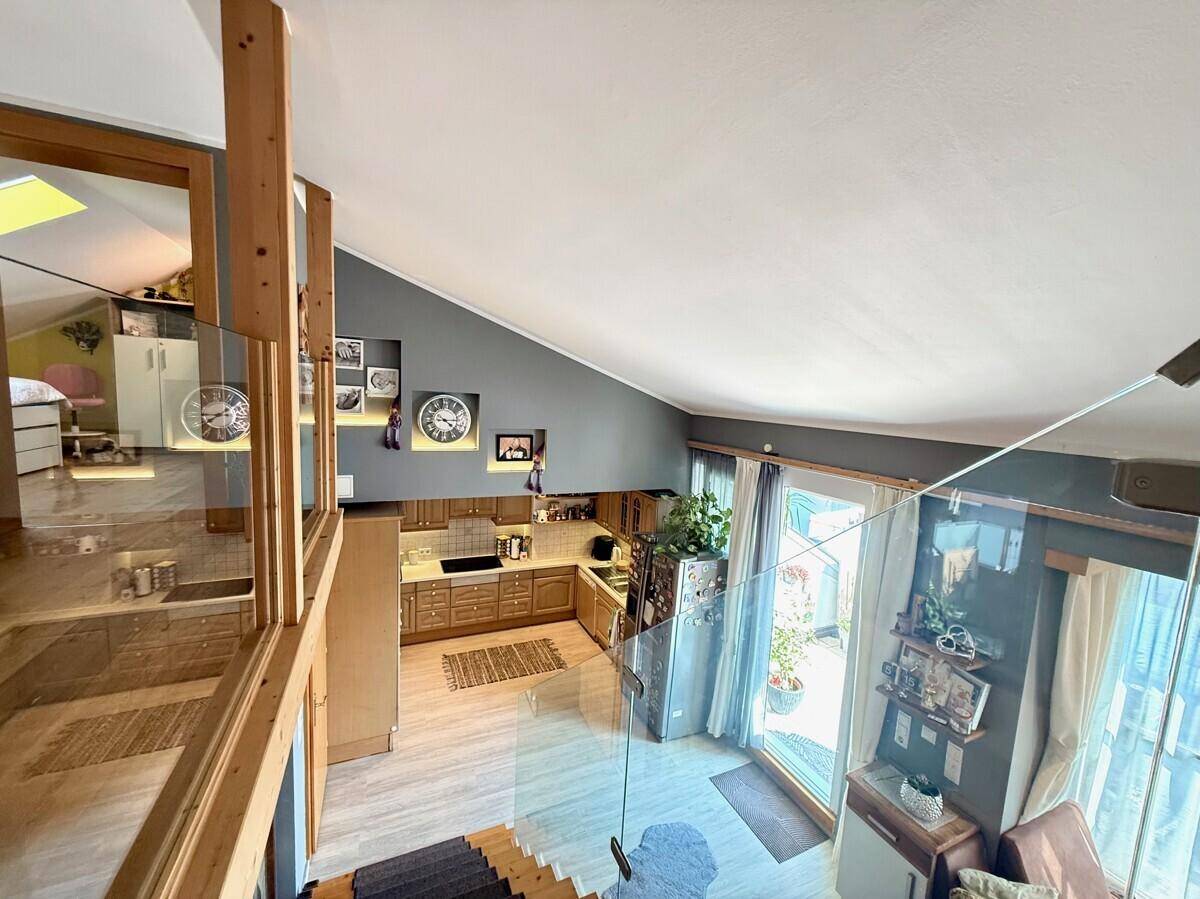 Geräumige Küche mit Holzelementen, offenem Design und Blick auf den Wohnbereich.