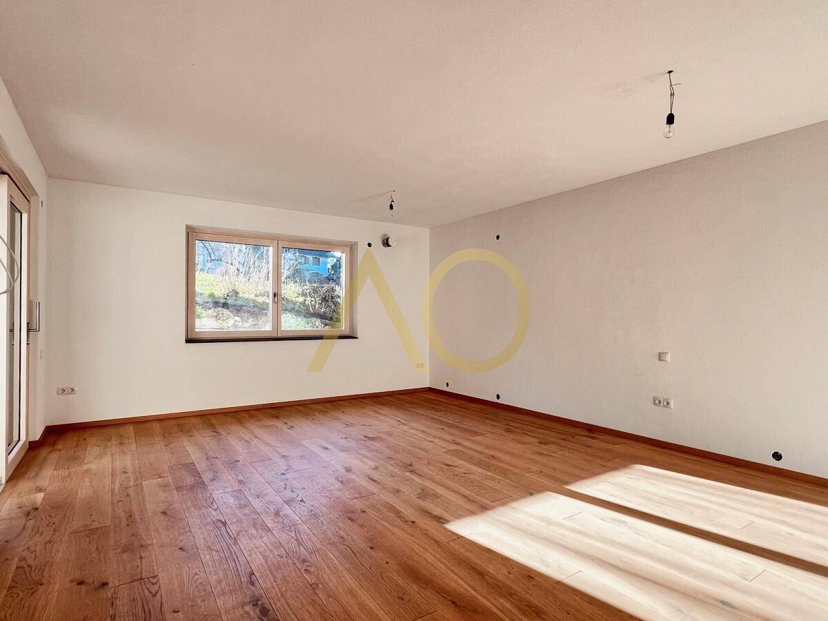 Geräumiger, heller Raum mit Holzboden und Fenster, bereit für individuelle Gestaltung.