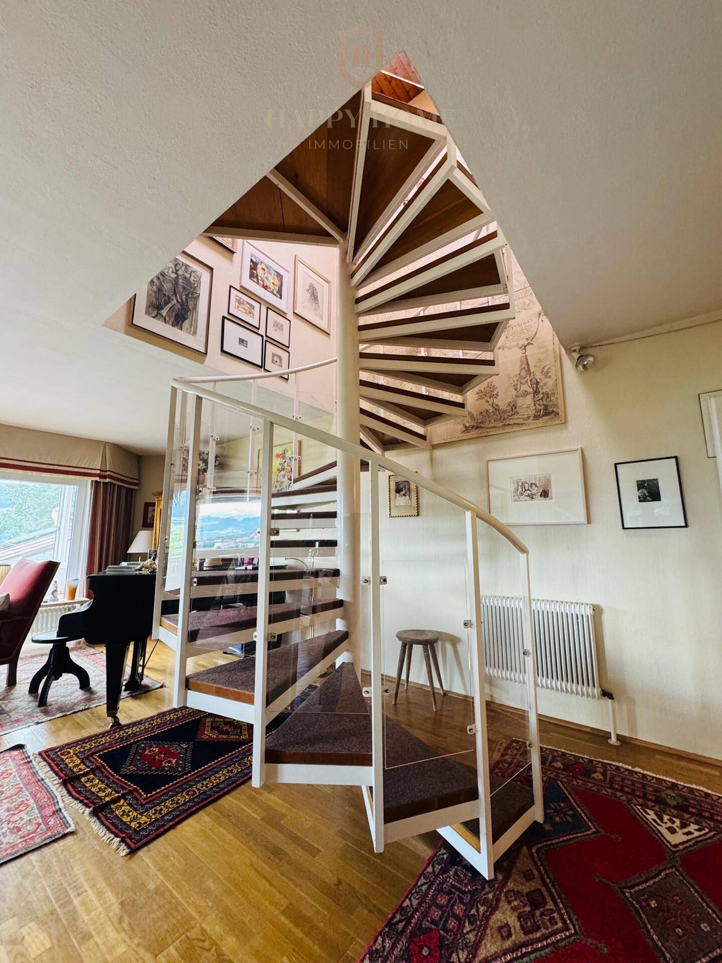 Elegante Wendeltreppe mit Glasgeländer als architektonisches Highlight im Wohnbereich.