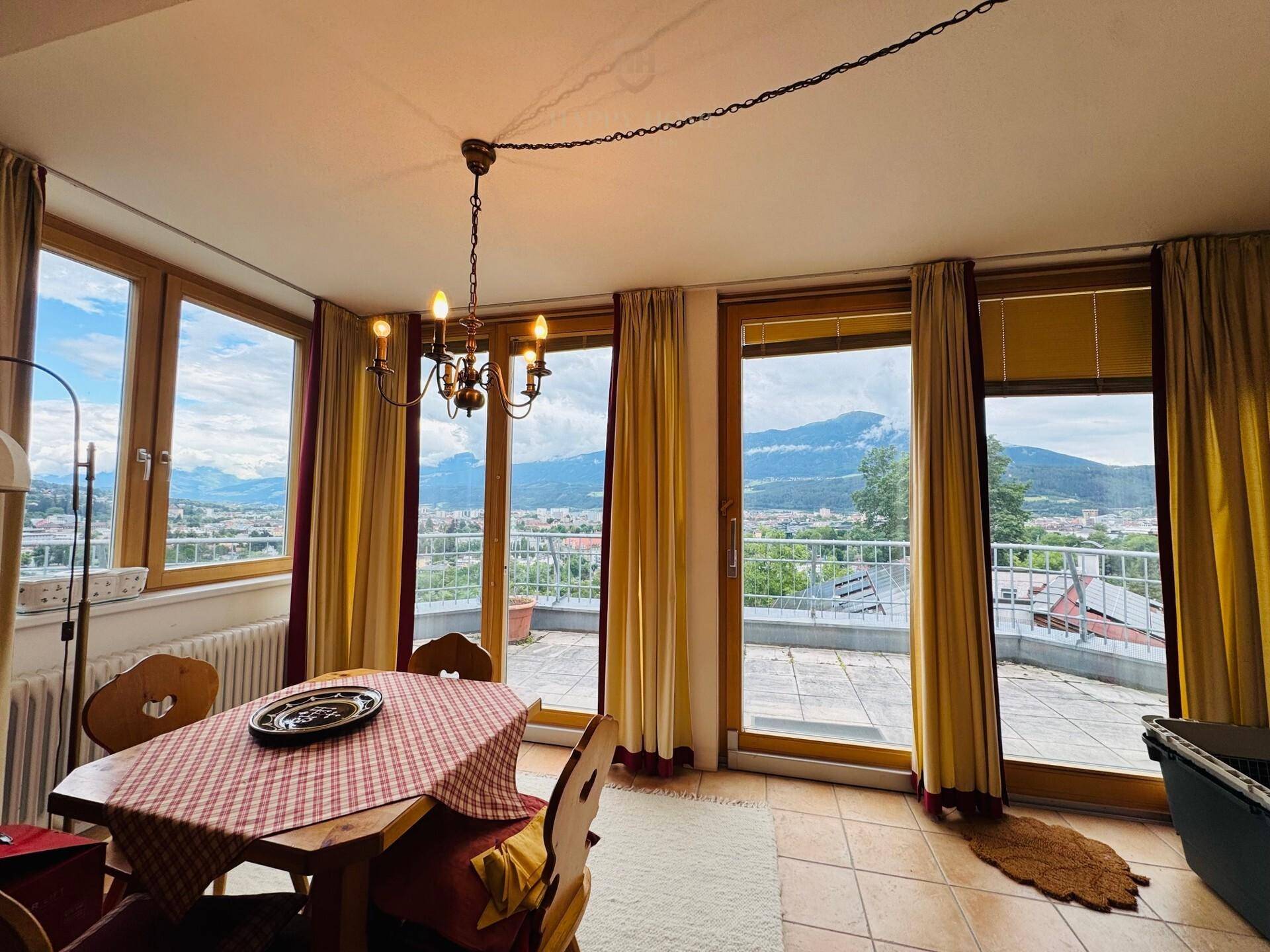 Gemütlicher Essbereich mit traditionellen Holzmöbeln, Fliesenboden und Zugang zur Terrasse mit Bergblick.