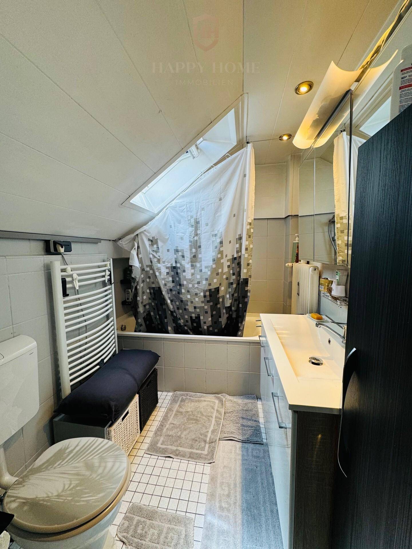 Badezimmer im Dachgeschoss mit Badewanne, WC, Waschbecken und beheiztem Handtuchhalter.
