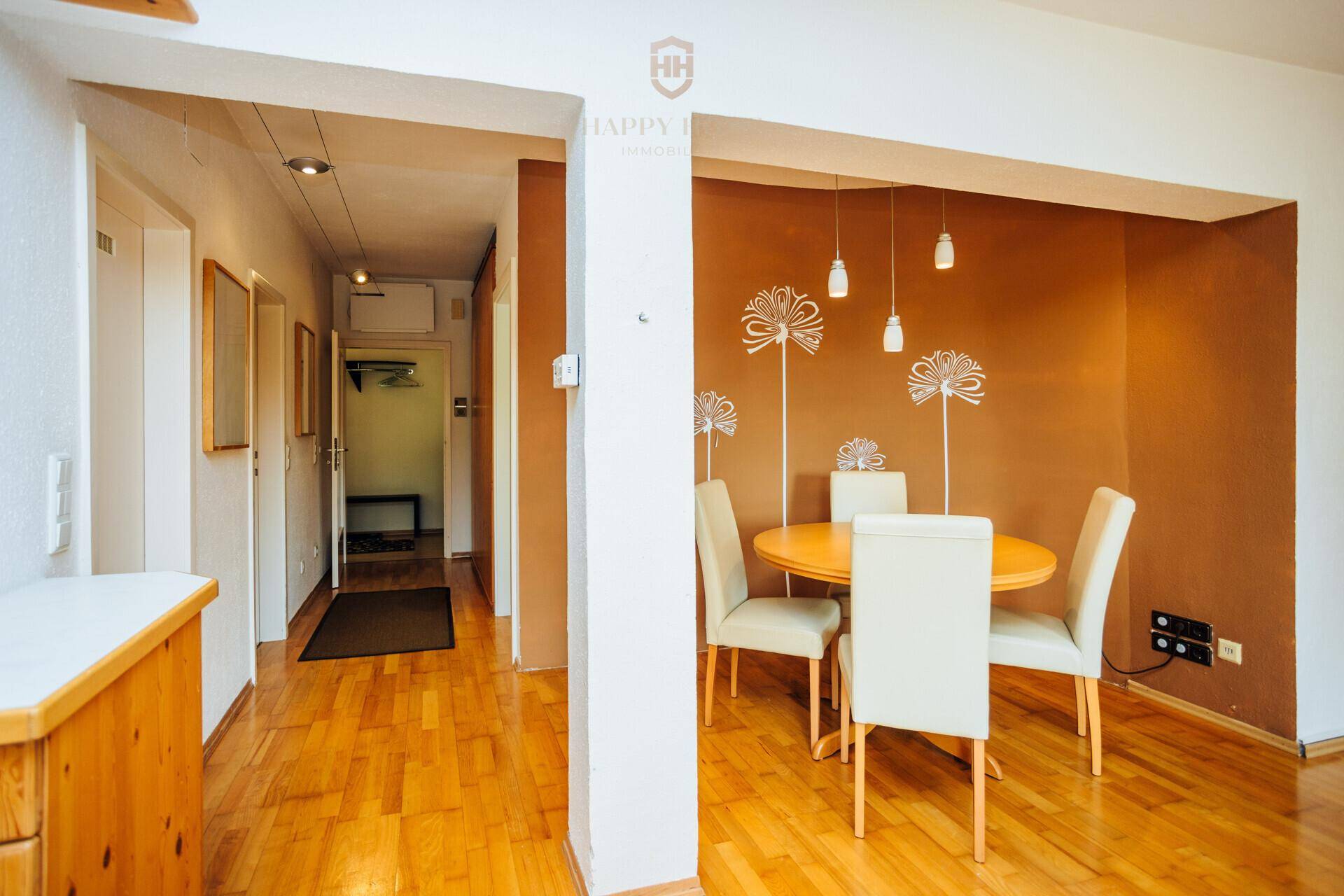 Gemütlicher Essbereich mit rundem Tisch und dekorativer Wandgestaltung neben dem Flur.