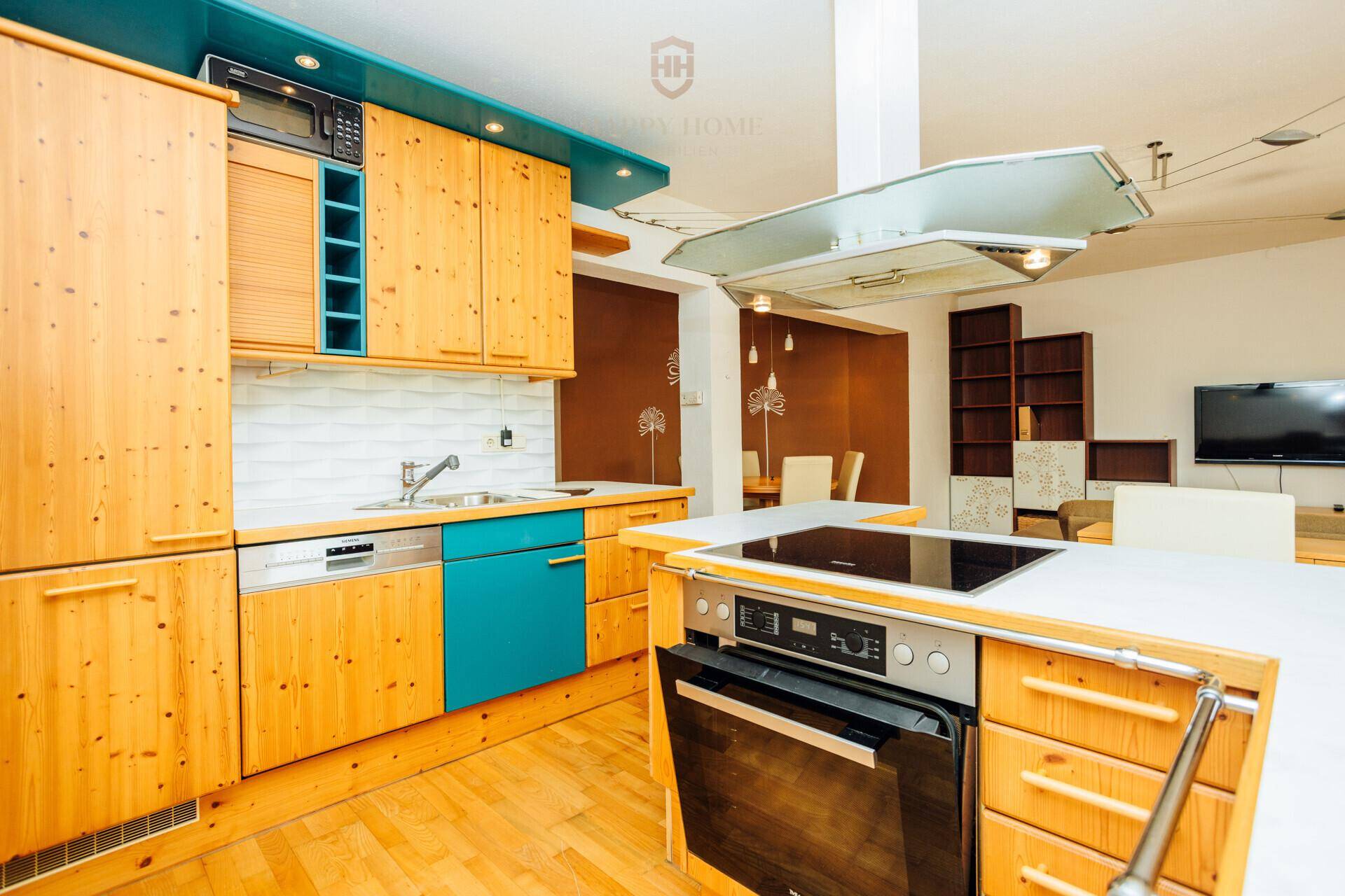 Funktionale Küche mit Holzschränken, blauen Akzenten und modernen Einbaugeräten.