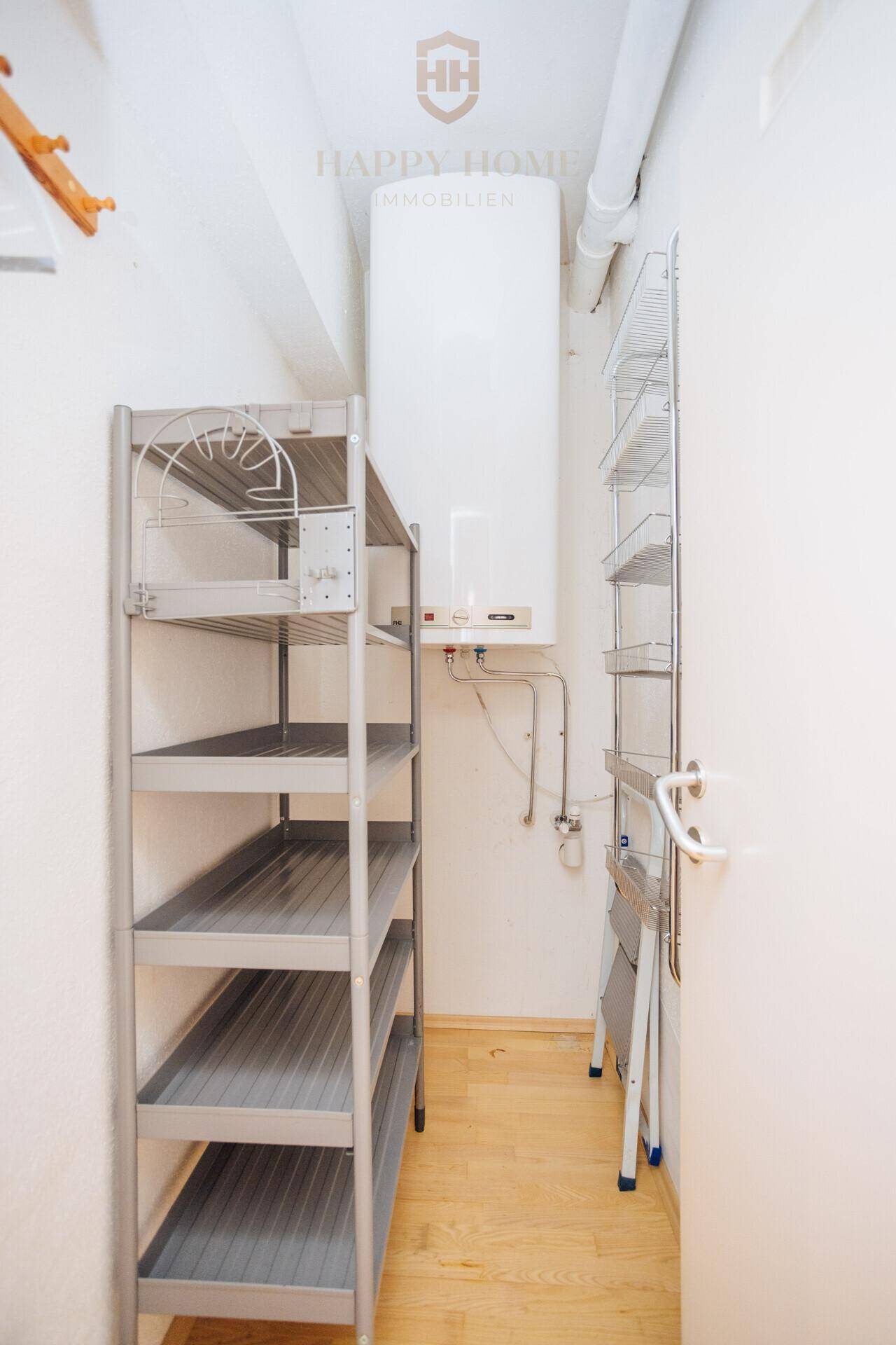 Praktischer Abstellraum mit Regalen und Warmwasserboiler für zusätzlichen Stauraum.