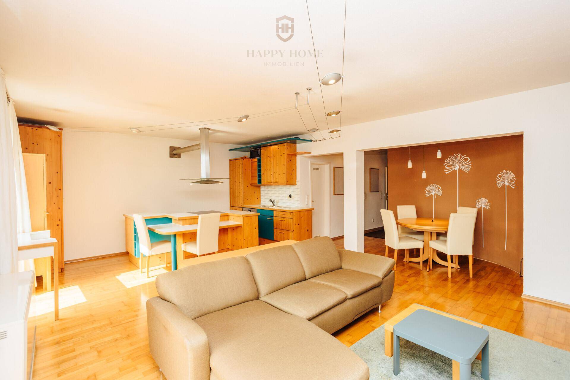 Heller, offener Wohn-Essbereich mit integrierter Küche, Holzfußboden und gemütlicher Sitzecke.