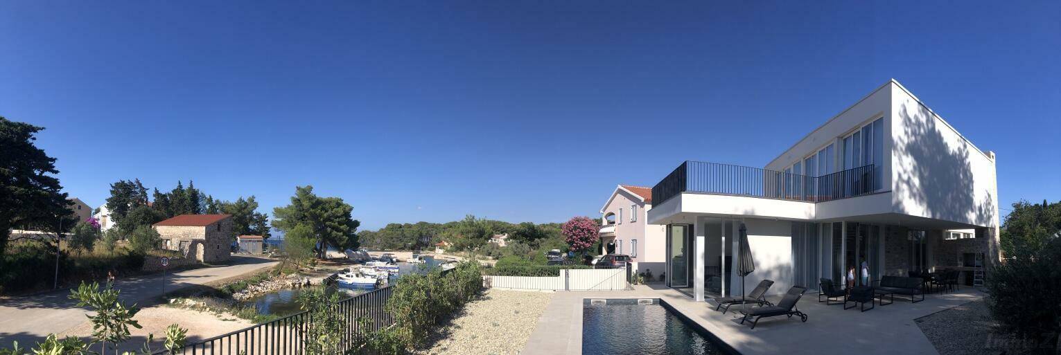 Weitläufiger Panoramablick auf die moderne Villa mit Pool und die umliegende Küstenlandschaft.
