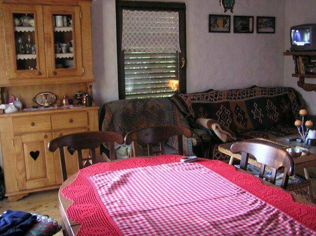 Gemütlicher Essbereich mit traditionellen Holzmöbeln und karierter Tischdecke.