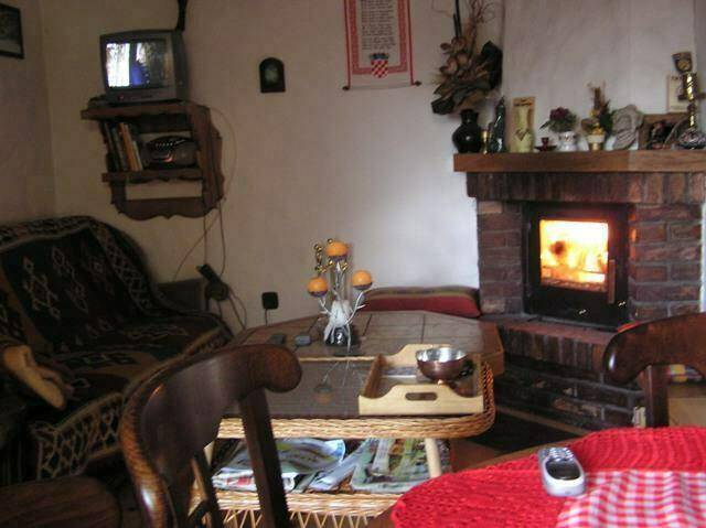 Wohnzimmer mit gemauertem Kamin, gemütlichem Sofa und traditioneller Einrichtung.