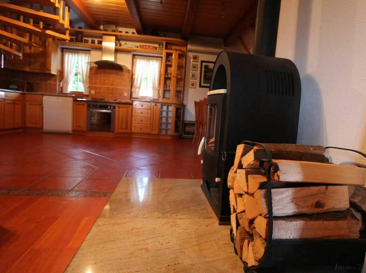 Kaminofen mit Holzscheiten im offenen Wohnbereich, der Wärme und Gemütlichkeit spendet.