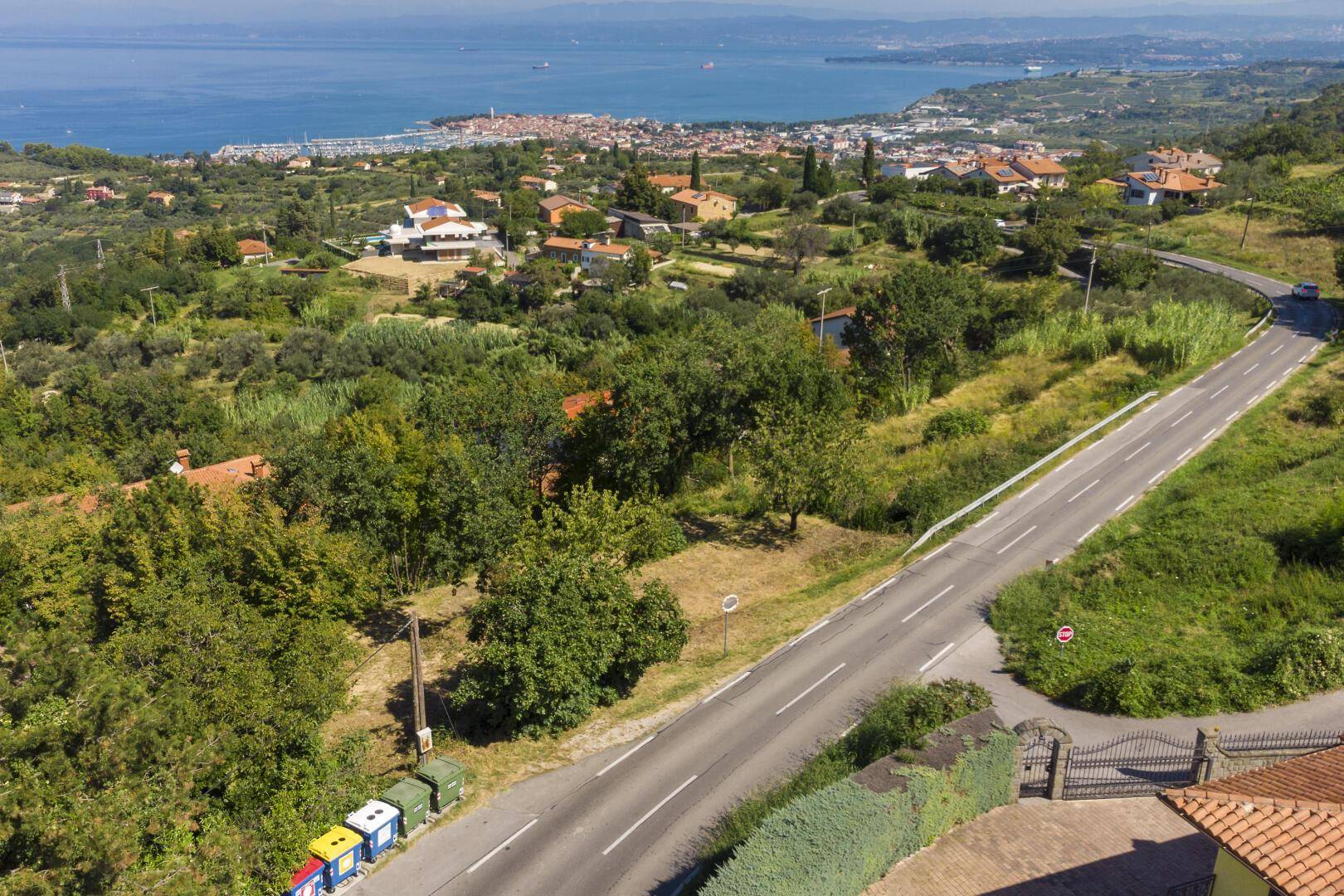 Luftaufnahme der ländlichen Umgebung mit einer Straße, Häusern und üppiger Vegetation.