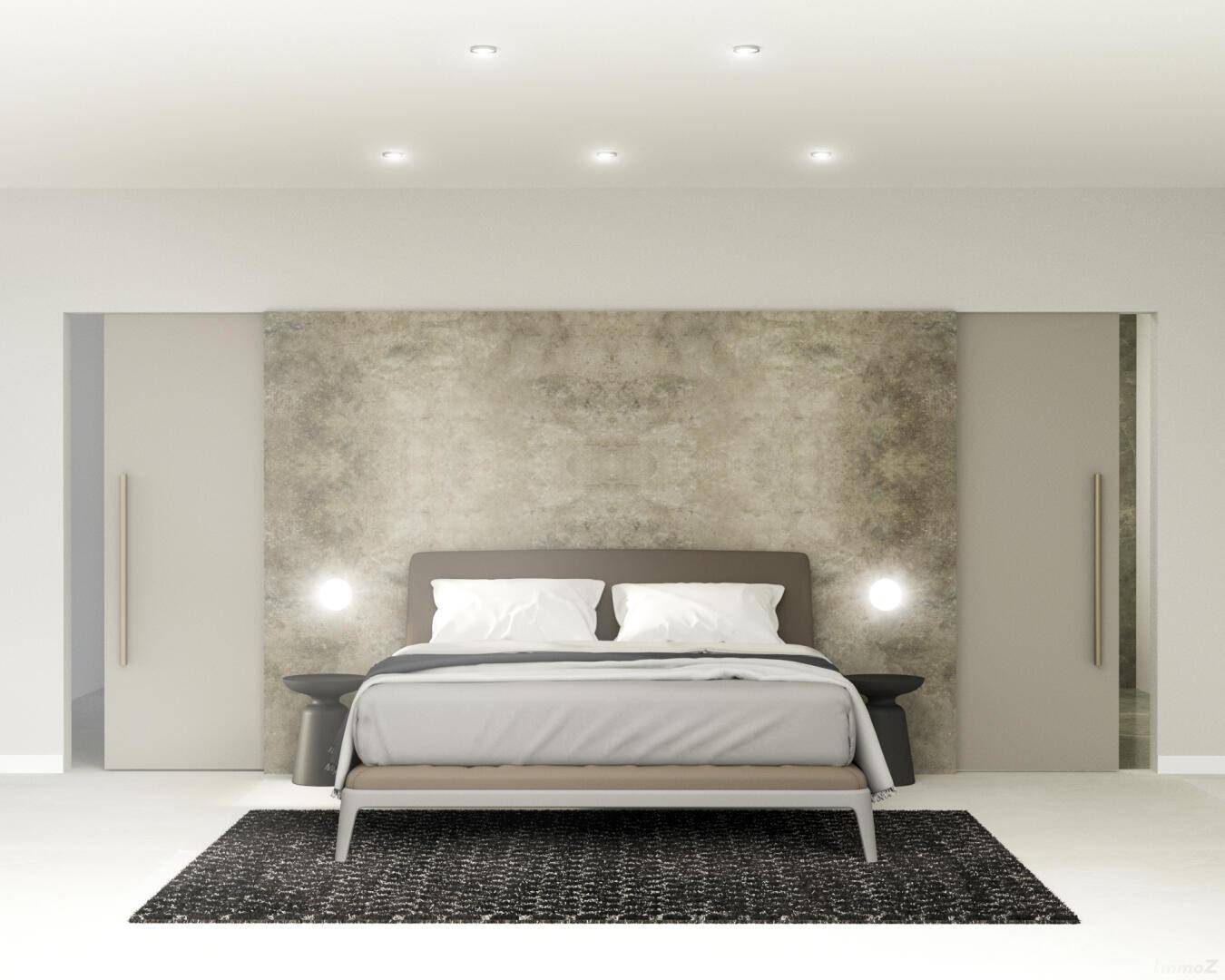 Elegantes Schlafzimmer mit einer strukturierten Wand hinter dem Bett und integrierten Schränken.