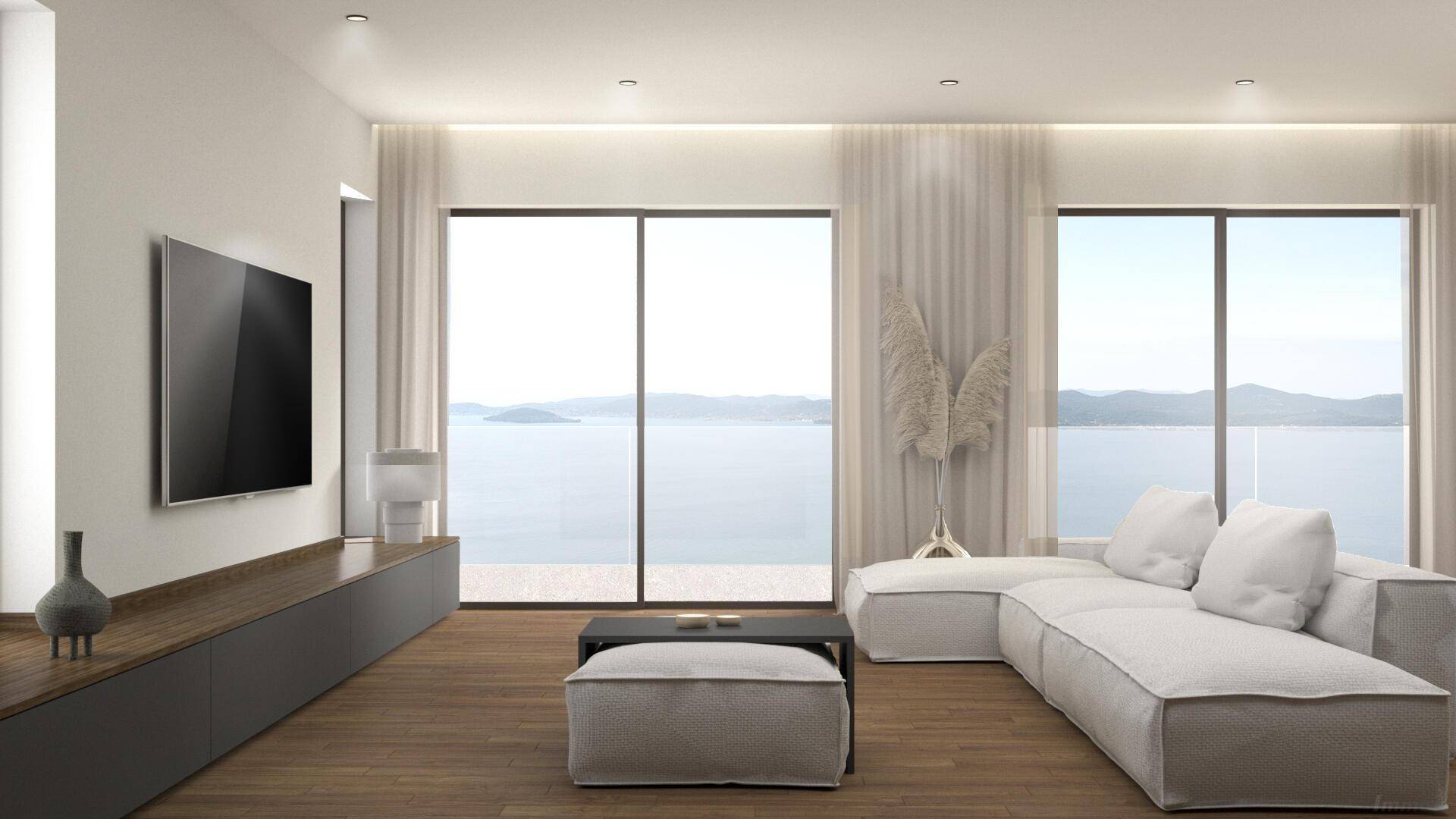 Helles Wohnzimmer mit großen Fenstern, die einen weiten Blick auf das Meer und die Landschaft bieten.