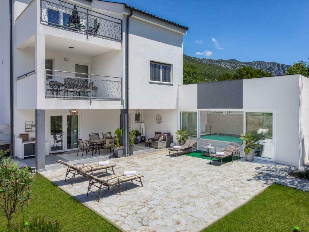Großzügiger Außenbereich mit Pool, Liegewiese und mehreren Terrassen für Entspannung und Unterhaltung.