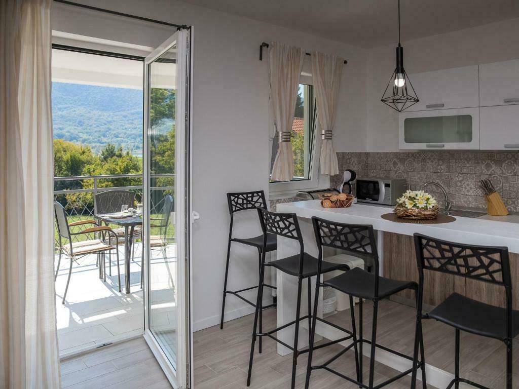Helle Küche mit Frühstücksbar und direktem Zugang zu einem Balkon mit schöner Aussicht.