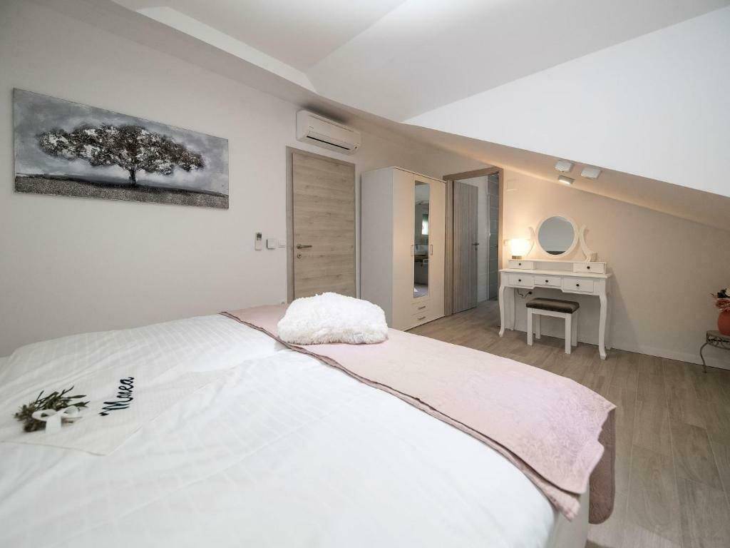 Helles Schlafzimmer im Dachgeschoss mit schrägen Wänden, Doppelbett und einem Schminktisch.