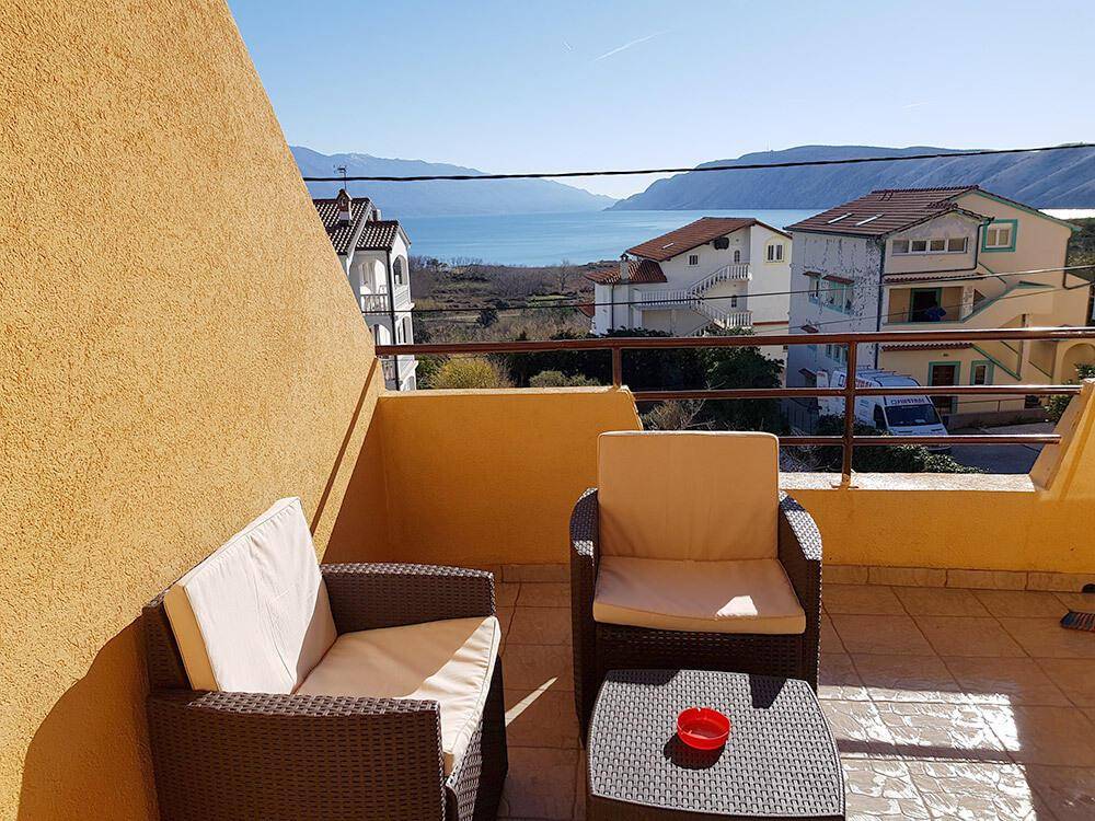 Gemütliche Terrasse mit Sitzgelegenheiten und weitem Blick auf das Meer und die Küste.