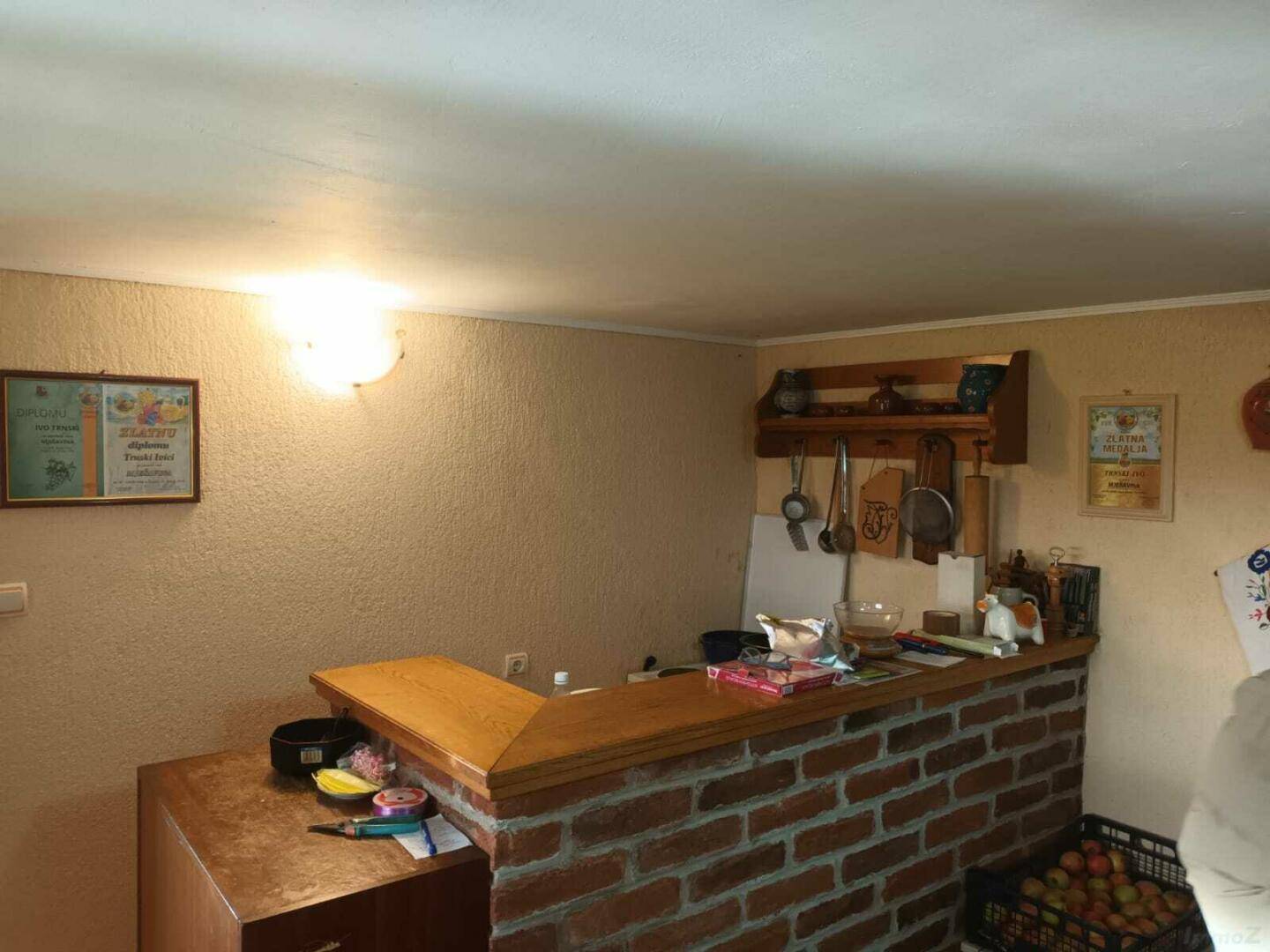 Rustikale Küchenzeile mit gemauerter Theke und Holzregalen für Utensilien.