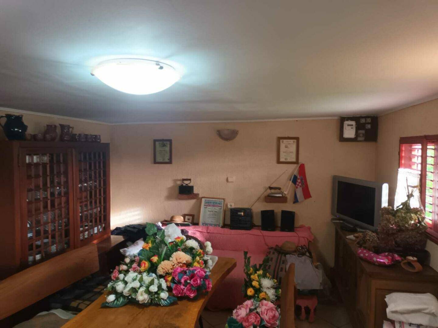 Gemütlicher Wohn- und Essbereich mit Holztisch, Sofa und traditioneller Dekoration.