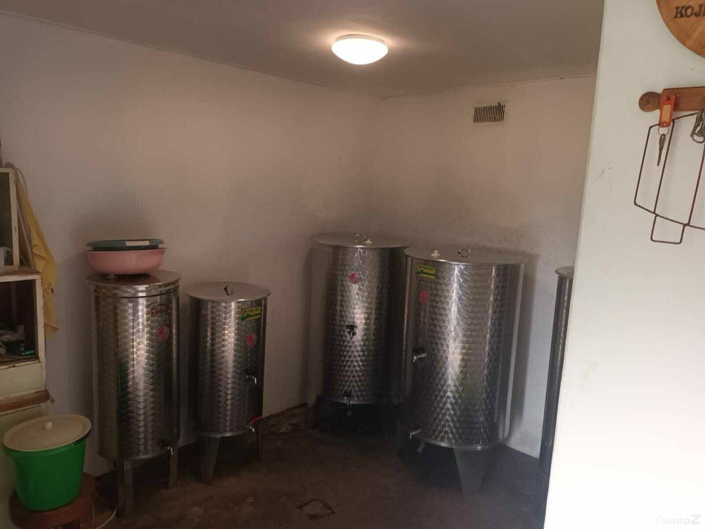 Lagerraum mit mehreren großen Edelstahltanks, wahrscheinlich für die Weinproduktion.
