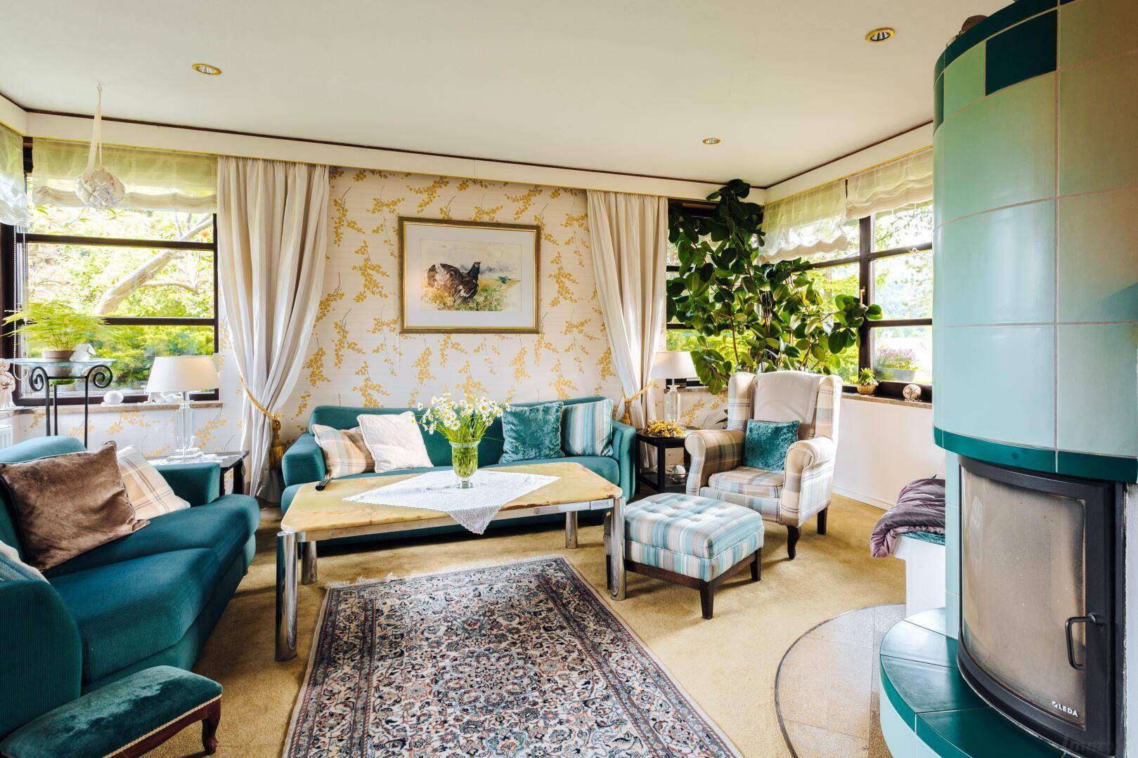 Gemütliches Wohnzimmer mit Kachelofen, bequemen Sofas und traditioneller Einrichtung.