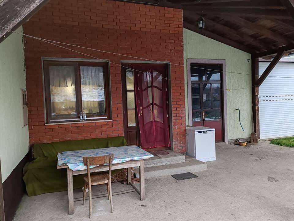 Überdachter Eingangsbereich mit Sitzgelegenheiten und Ziegelmauerwerk.