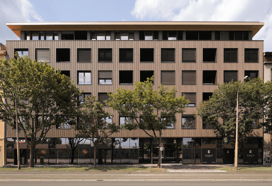 Straßenansicht eines modernen Gebäudes mit Holzfassade und vielen Fenstern.