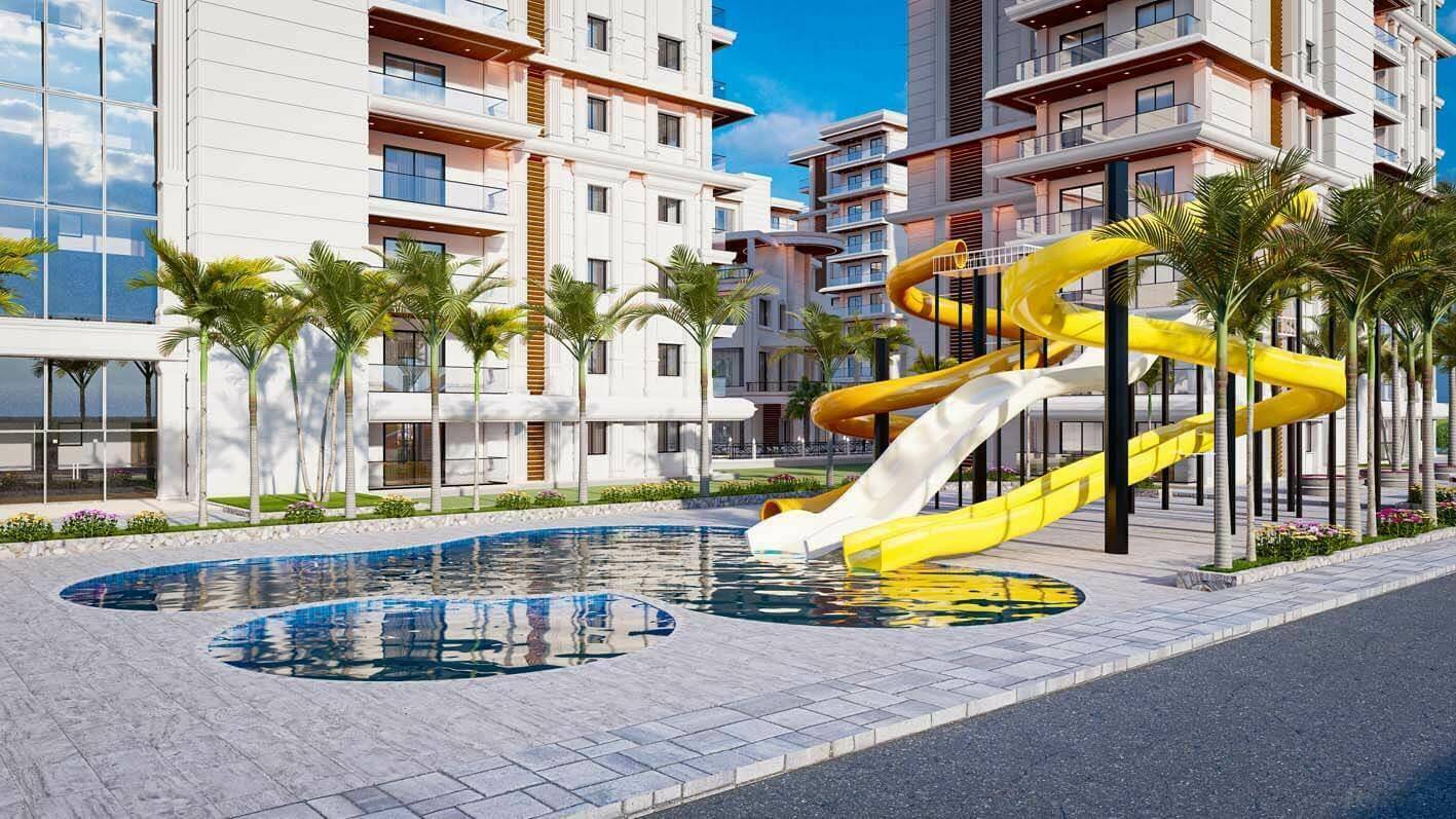 Kinderfreundlicher Poolbereich mit bunten Wasserrutschen und umliegenden Palmen.