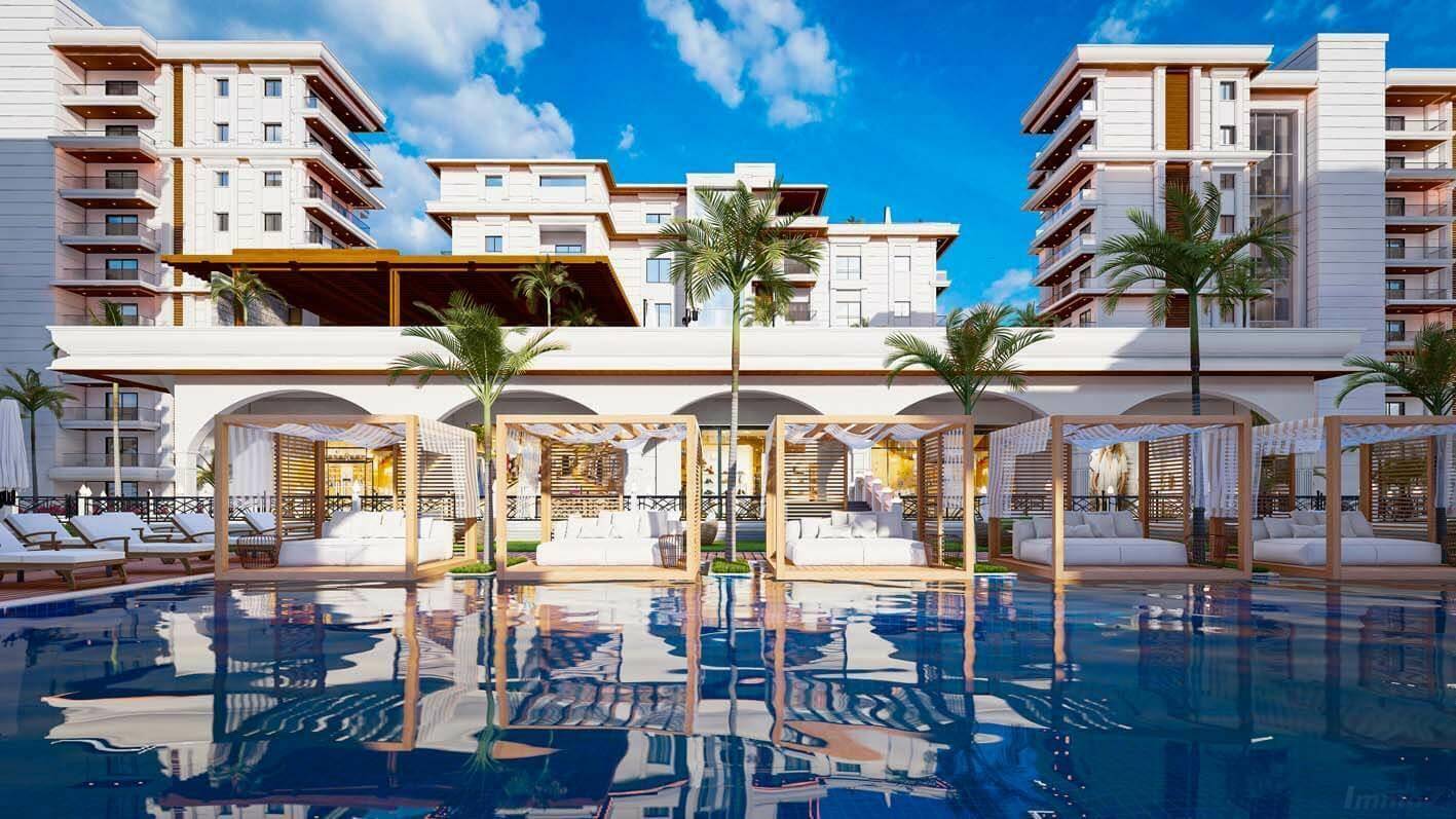 Großer Außenpool mit luxuriösen Cabanas und der modernen Architektur der Wohnanlage.