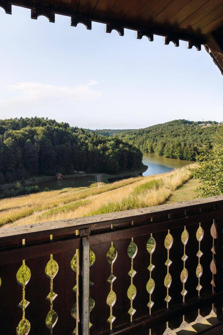 Malerischer Ausblick vom Balkon auf den See und die umliegende bewaldete Landschaft.