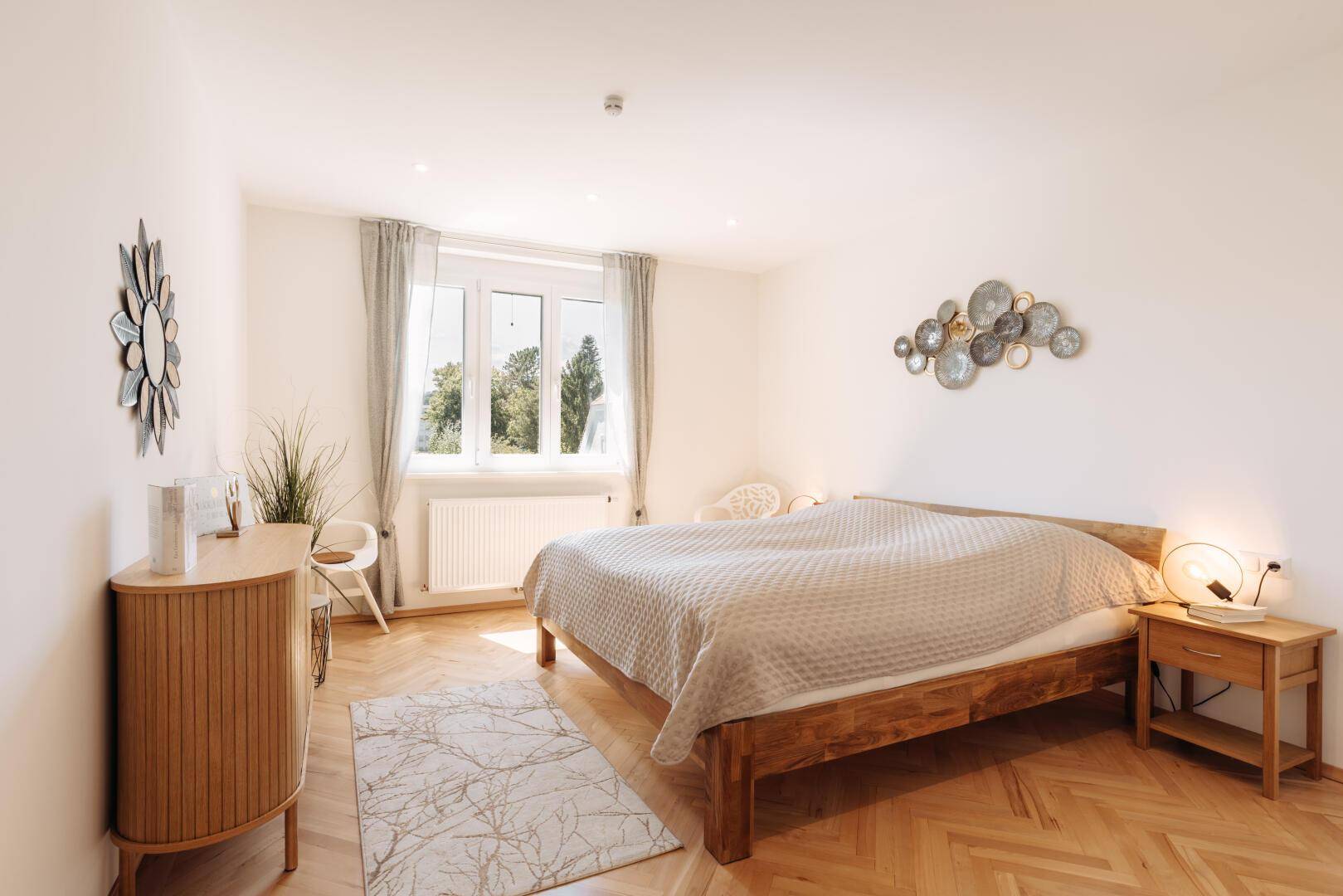 Geräumiges Schlafzimmer mit Doppelbett, Nachttischen und dekorativen Wandelementen.