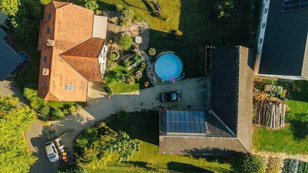 Luftaufnahme des Anwesens mit Wohnhaus, Nebengebäuden, Pool und großem Garten.