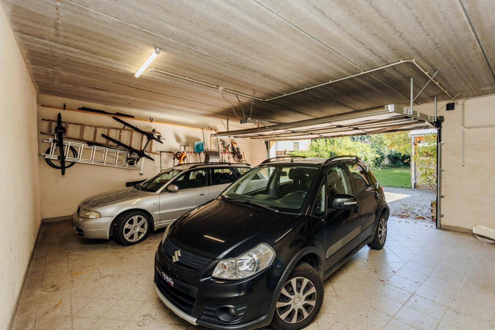 Geräumige Garage mit Platz für zwei Fahrzeuge und Stauraum.