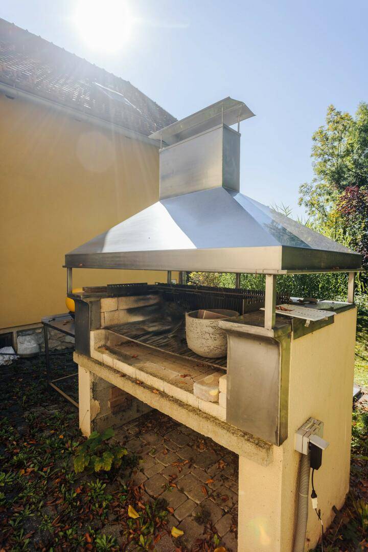 Gemauerter Grillplatz im Freien mit Abzugshaube, bereit für gesellige Abende.