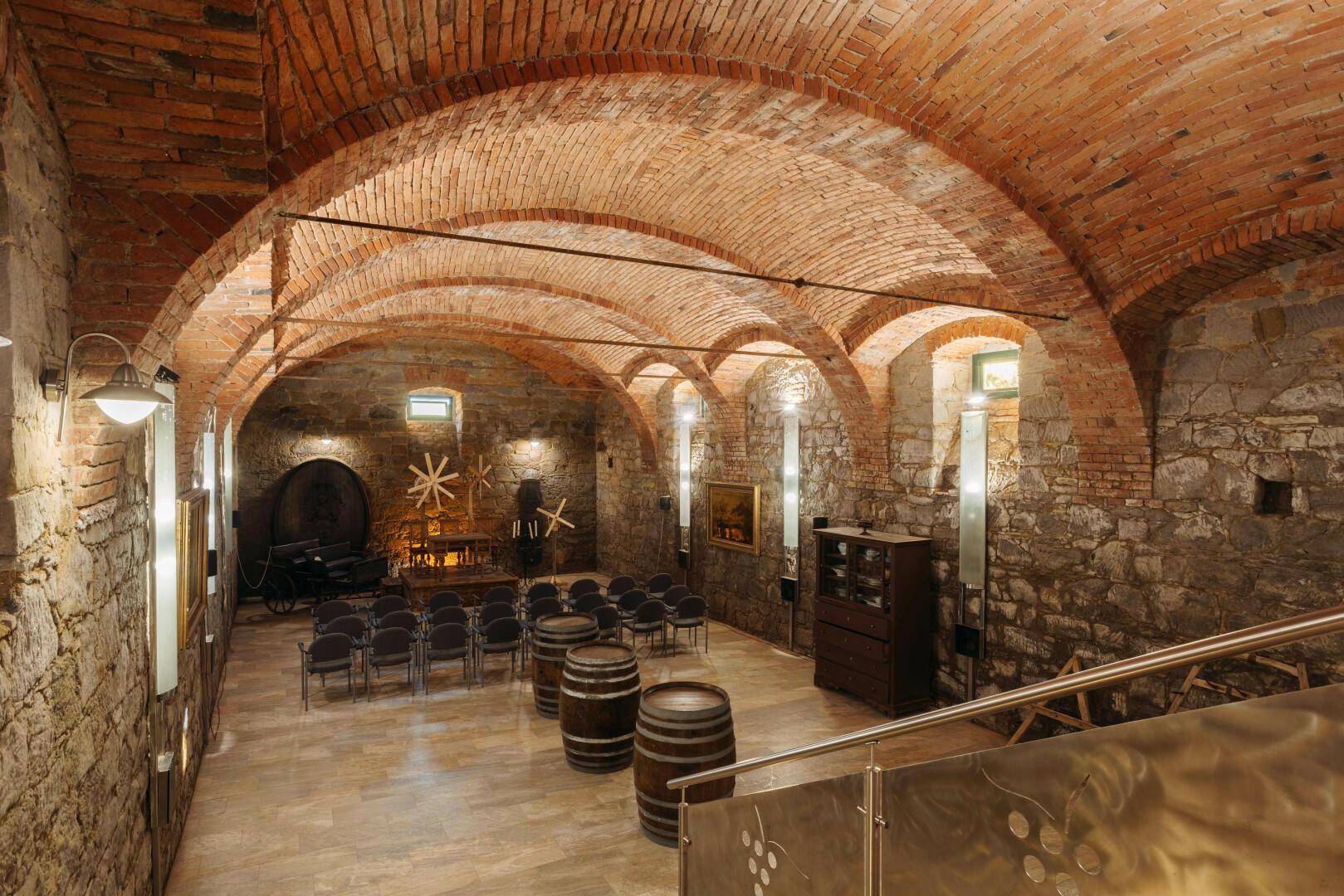 Historischer Gewölbekeller mit Steinmauern, Holzböden und Sitzgelegenheiten für Veranstaltungen.
