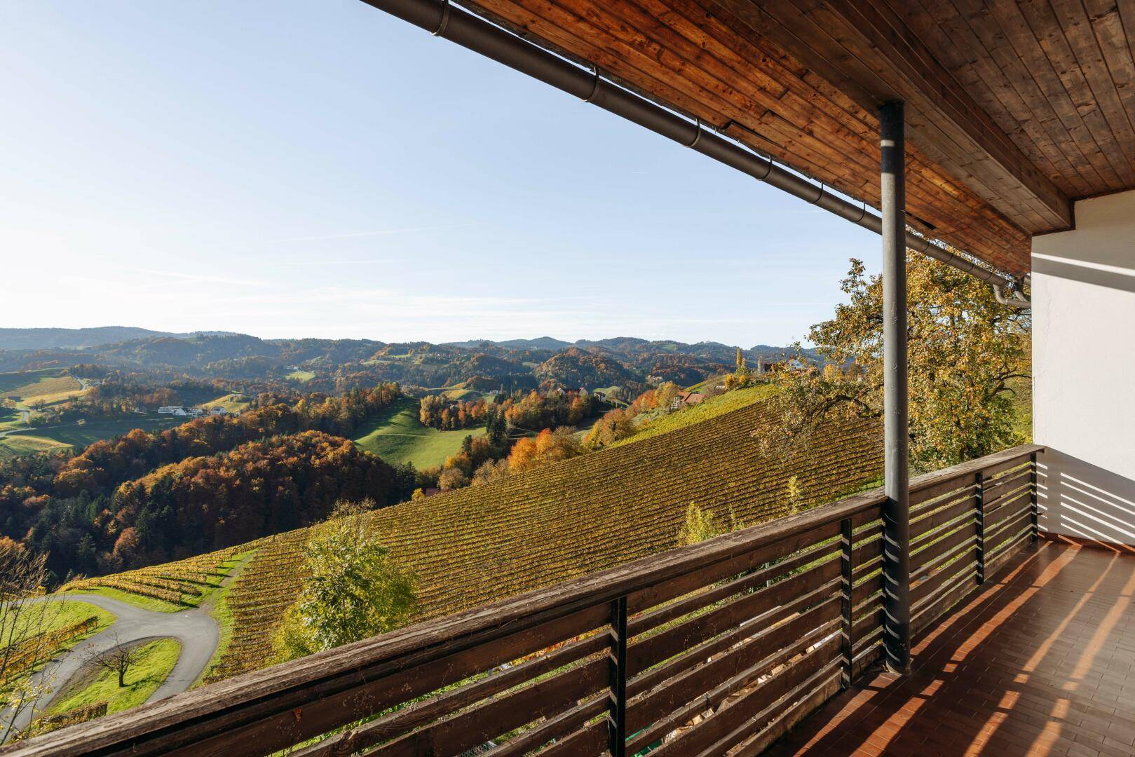 Weitläufige Loggia mit Holzboden und atemberaubendem Panoramablick auf die Weinberge.