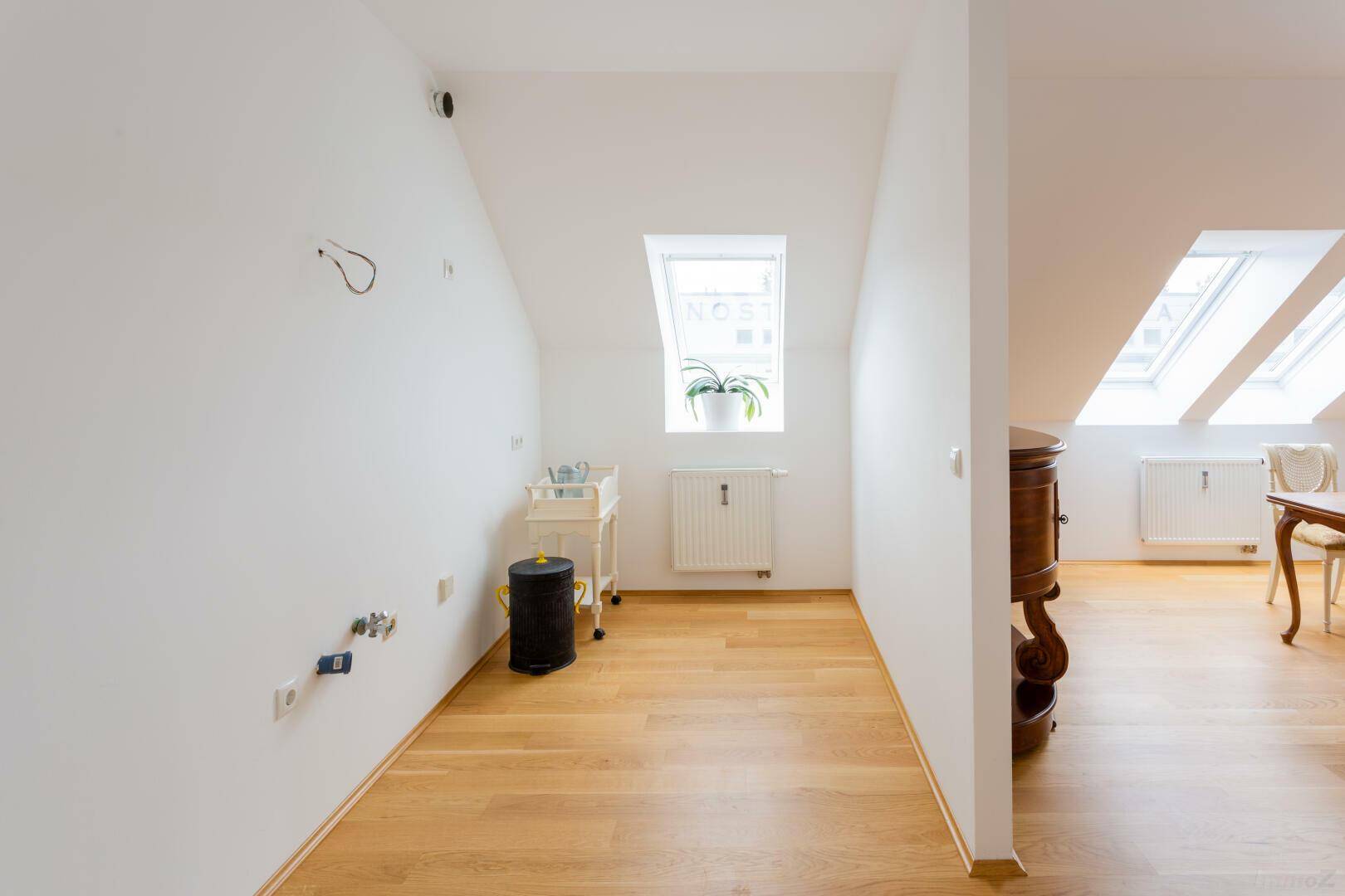 Heller Raum im Dachgeschoss mit Dachfenster, Parkettboden und vorbereiteten Anschlüssen.