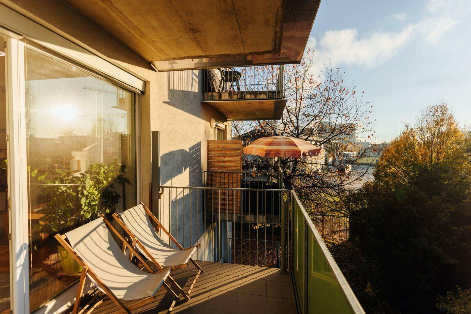 Sonniger Balkon mit Liegestühlen und Blick auf die Umgebung, ideal zum Entspannen im Freien.