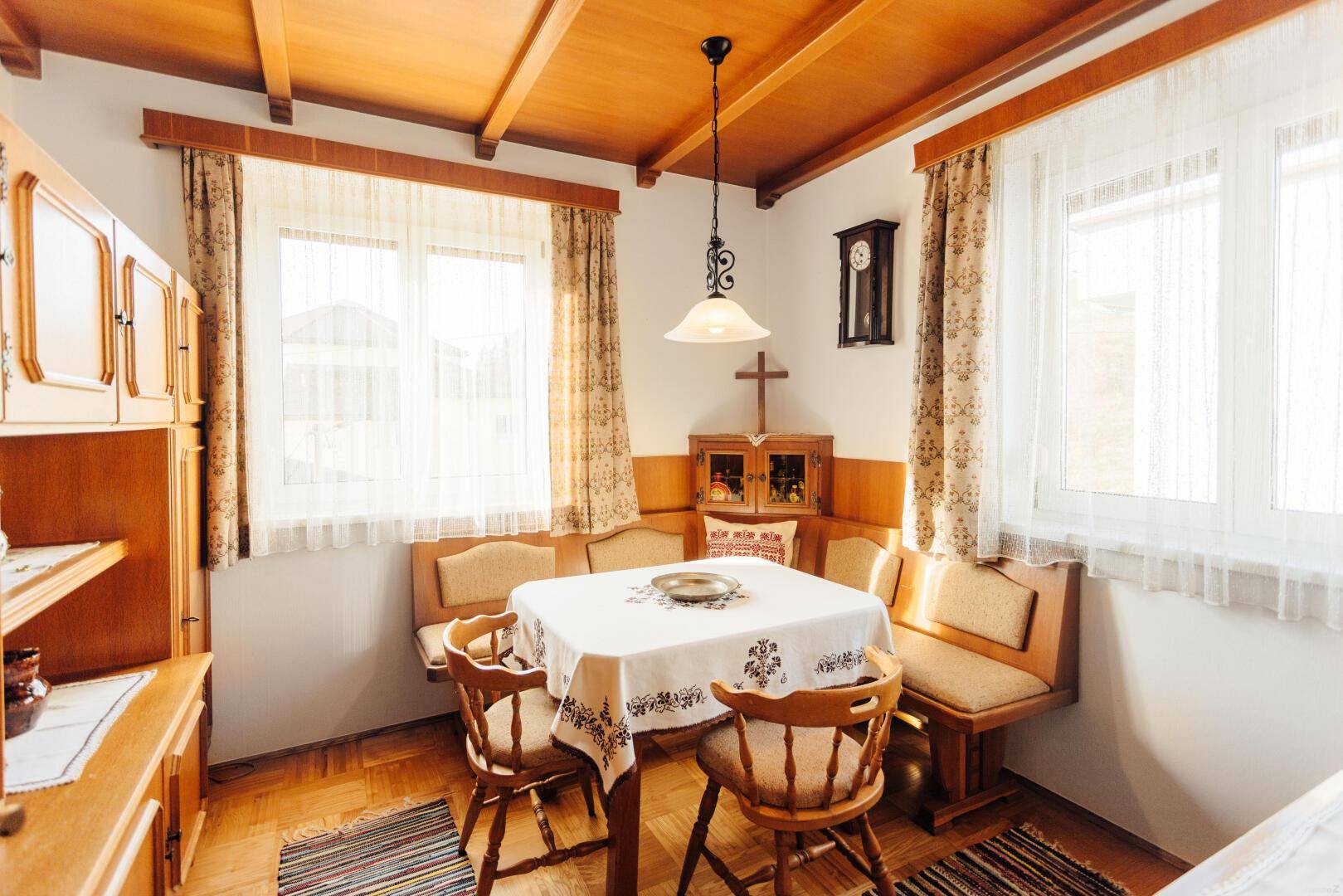 Traditioneller Essbereich mit Holztisch, Eckbank und Holzdecke.