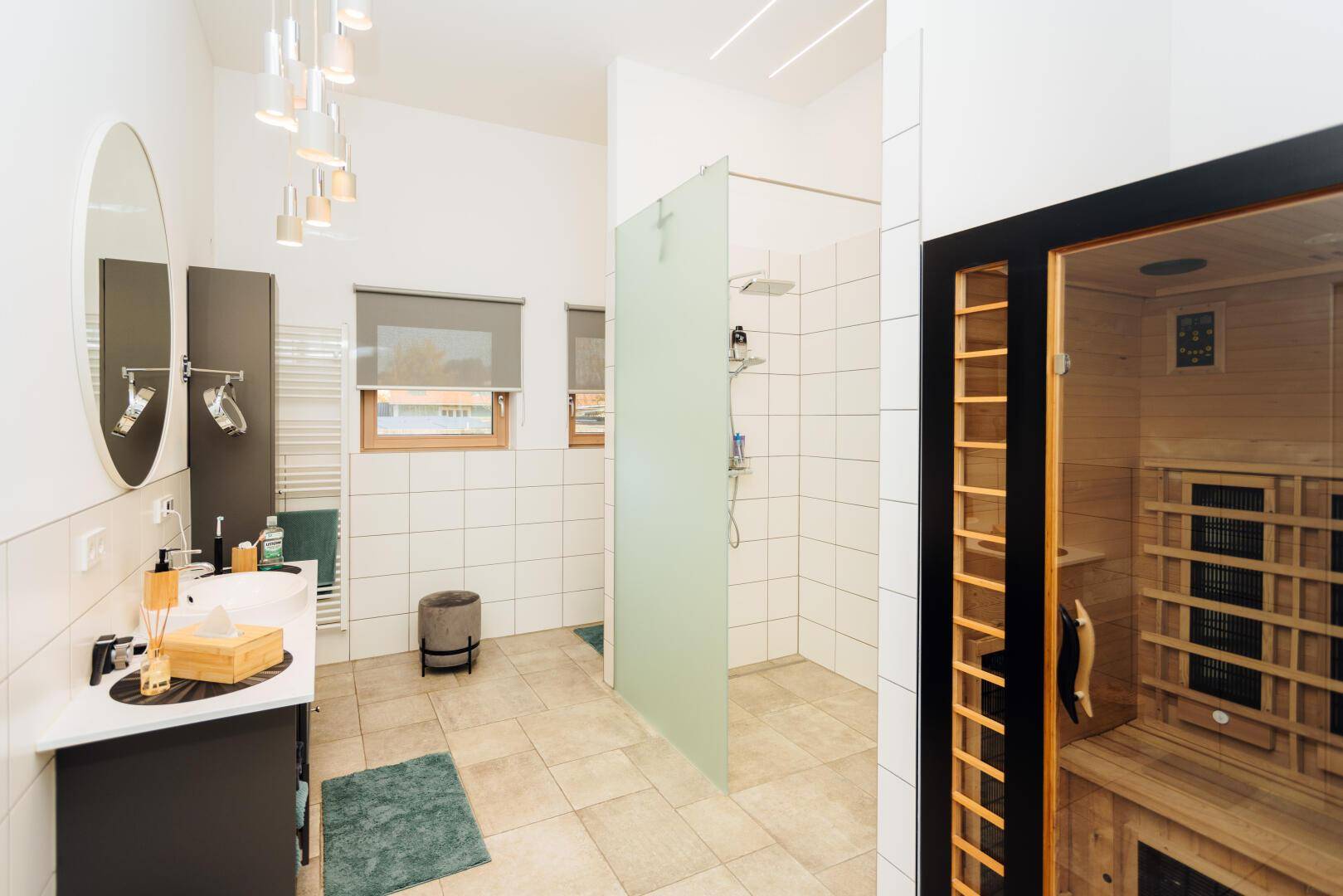Modernes Badezimmer mit Dusche, Doppelwaschbecken und integrierter Sauna.