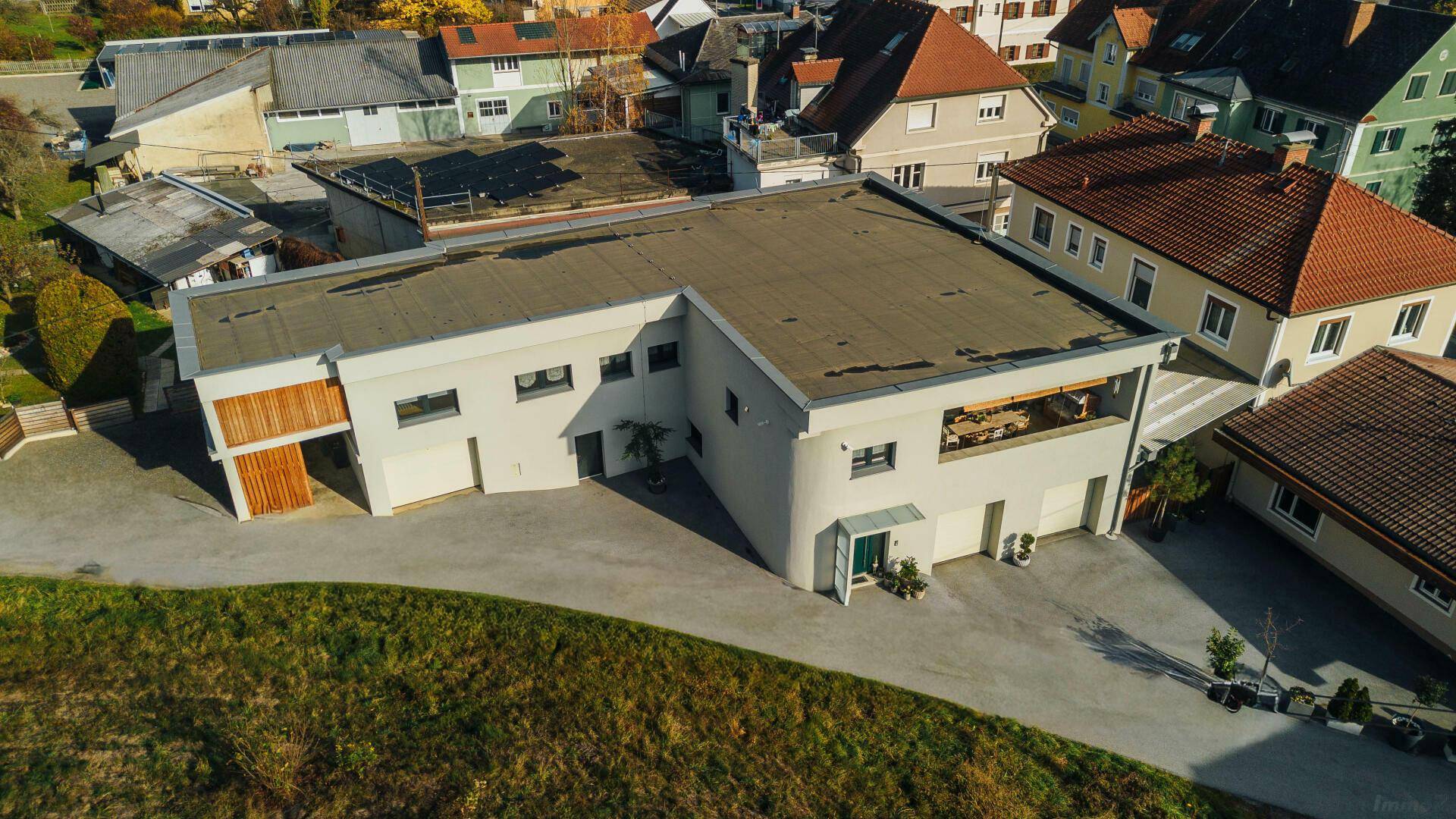 Moderne Wohnanlage mit Flachdach, Garagen und großzügiger Auffahrt.