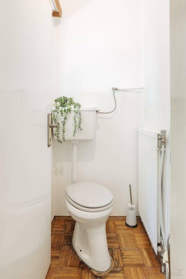 Kleines Gäste-WC mit Toilette, Heizung und Parkettboden.