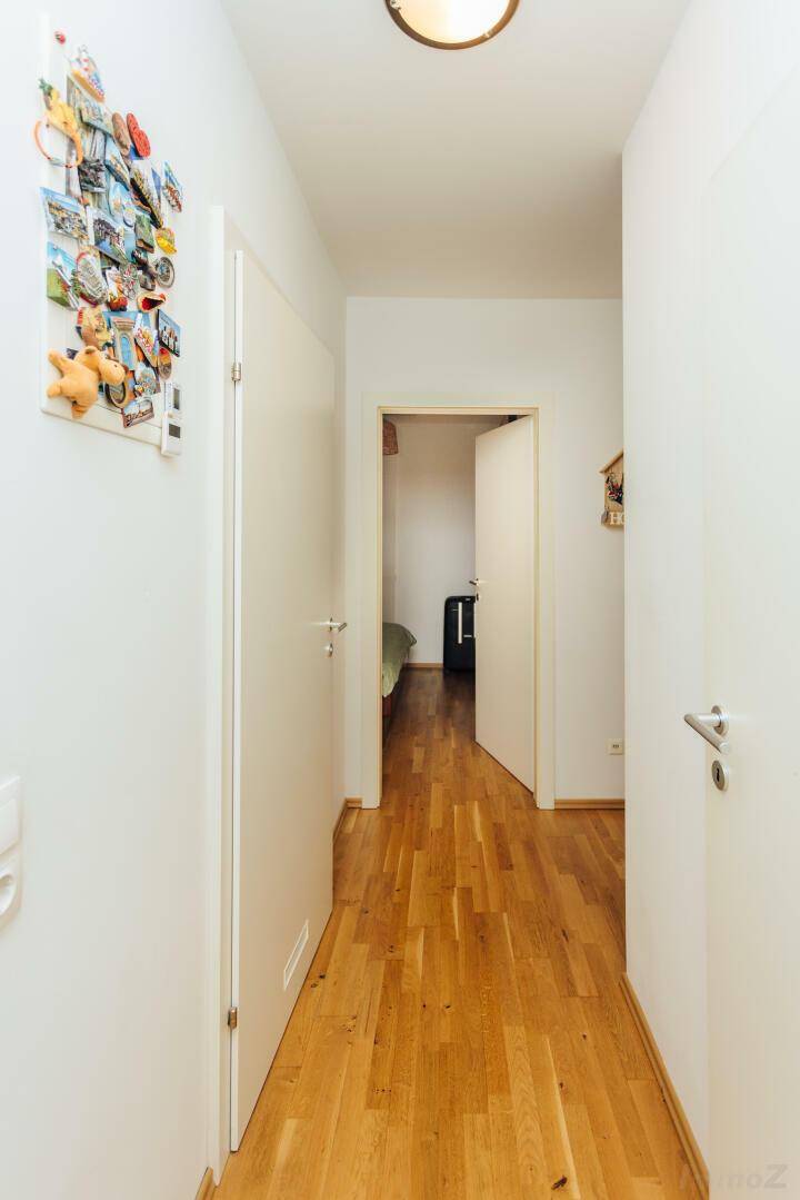 Heller Flur mit Parkettboden und Zugang zu den verschiedenen Zimmern der Wohnung.