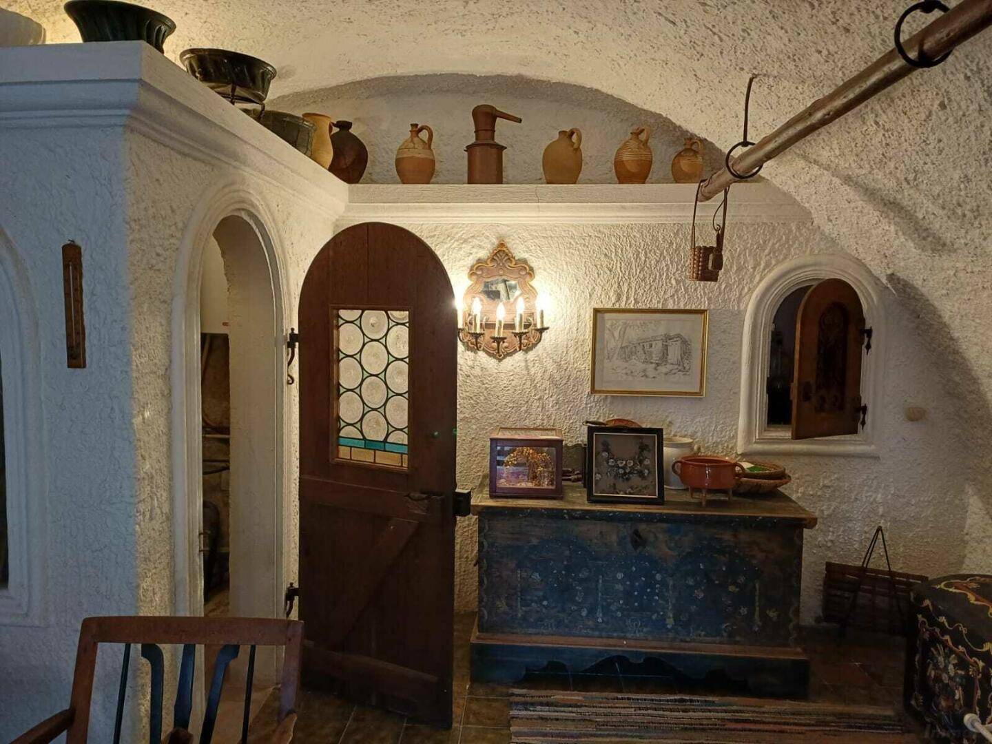 Rustikaler Flur mit Holztür, gewölbter Decke und traditionellen Dekorationselementen.